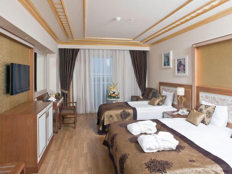 Camera d'hotel elegante con due letti, pavimento in legno e arredi moderni.