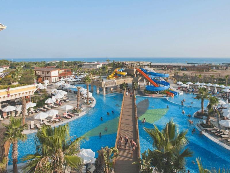 Grande resort con parco acquatico, piscine, scivoli d'acqua e lettini vicino al mare