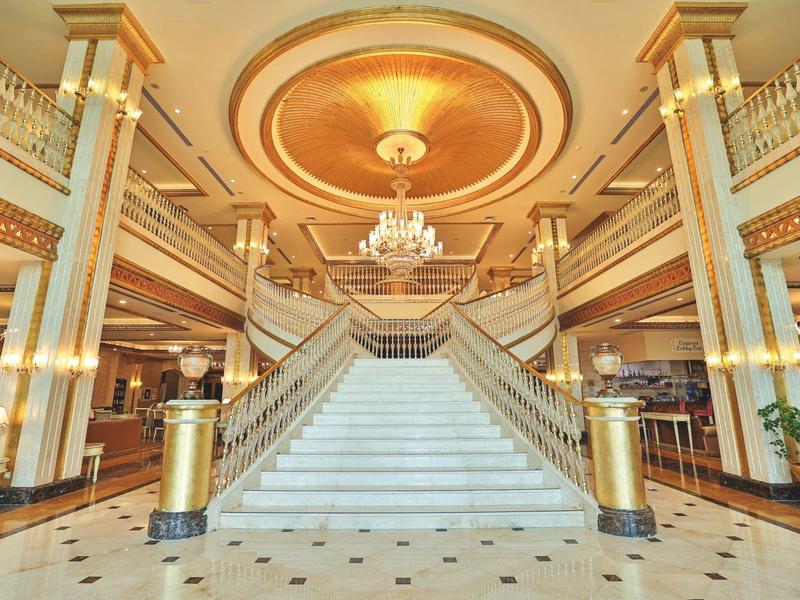 Lussuosa hall d'hotel con grande scala in marmo bianco e lampadario