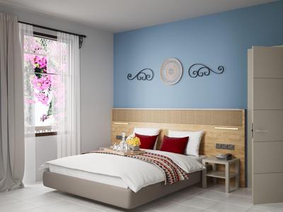 Modernes Hotelzimmer mit Doppelbett, blauer Wand, Nachttischen und Fenster mit weißen Vorhängen.