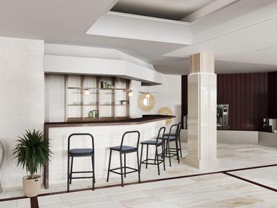 Moderner Hotelbarbereich mit hohen Hockern, minimalistischer Einrichtung und hellem Marmorboden.