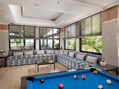 Modernes Hotel-Lounge mit großem Panoramafenster und Billardtisch im Vordergrund.
