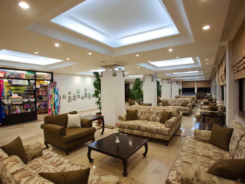 Salon spacieux d'hôtel avec fauteuils confortables et éclairement moderne.