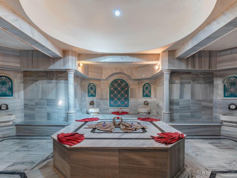 Elegante hammam turco con pareti in marmo e lastra centrale riscaldata.