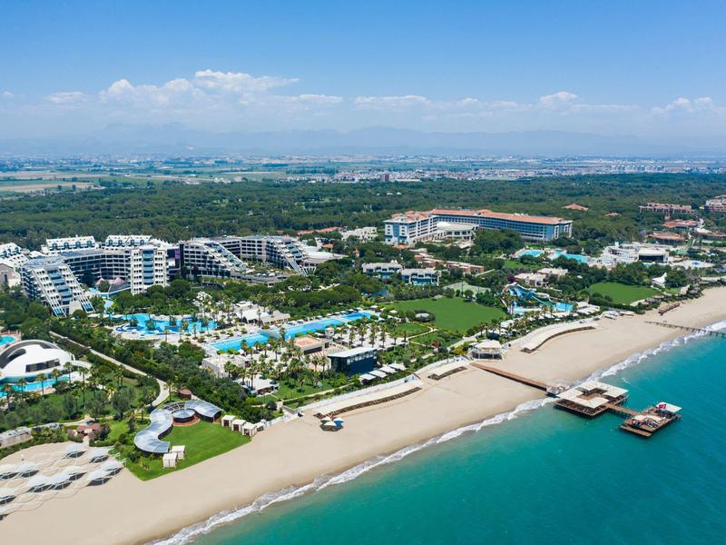 Vue aérienne d'un grand hôtel avec piscines et plage de sable au bord de la mer