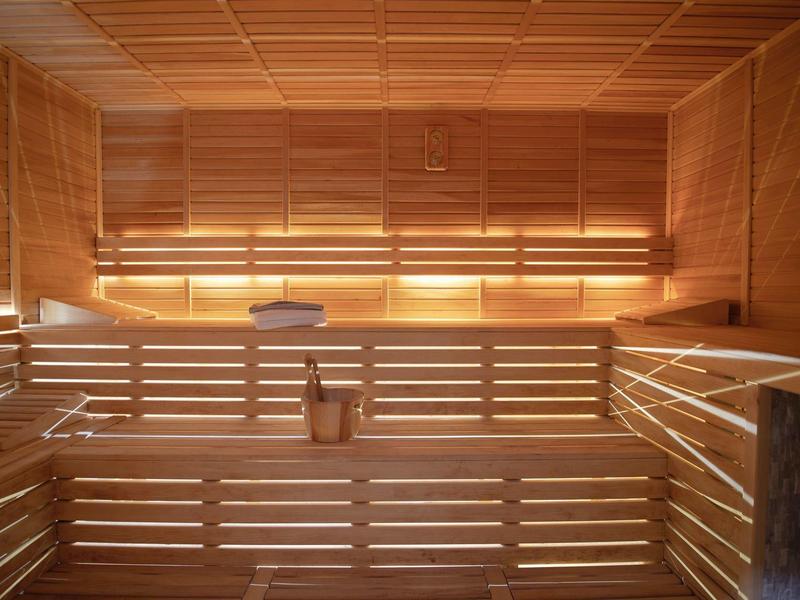 Interno di una sauna con panche in legno e illuminazione soffusa