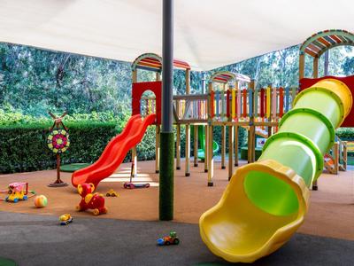 Area giochi colorata per bambini con scivoli sotto una tettoia all'aperto