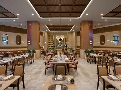 Elegante ristorante dell'hotel con tavoli e sedie eleganti, luce calda e design moderno.