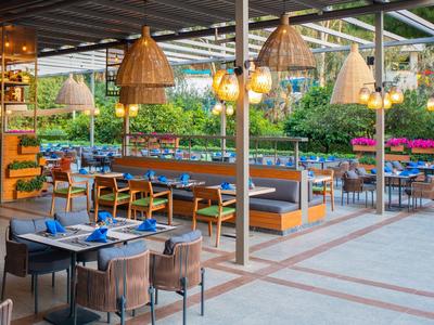 Area pranzo all'aperto con arredi moderni e illuminazione esterna raffinata.