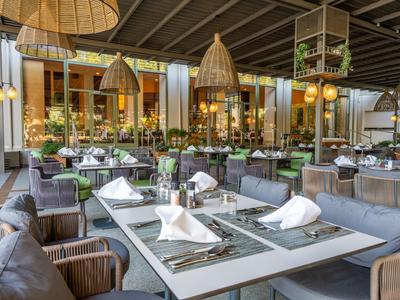 Ristorante elegante con tavoli apparecchiati e sedie confortevoli per ospiti dell'hotel.