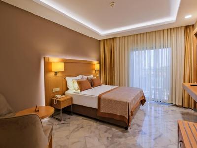 Nowoczesny pokój hotelowy z łóżkiem podwójnym, balkonem i wygodnym miejscem do siedzenia.