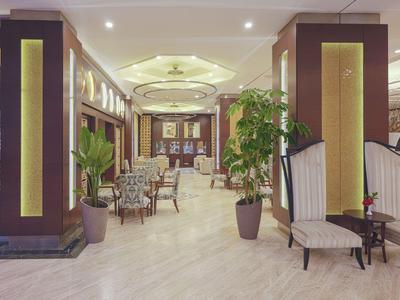 Eleganter Hotel-Lobbybereich mit bequemen Sesseln, Pflanzen und warmem, indirektem Licht.