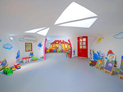 Kinderspielzimmer mit bunten Wandmalereien und Spielzeug in einem Hotel mit Schrägdach.