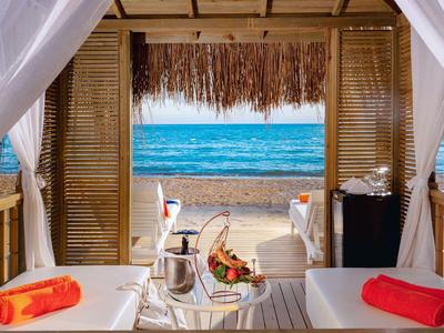 Luxuriöse Strandkabine mit Blick auf das Meer und servierten Getränken.