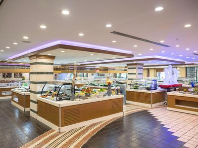Moderne Buffetstationen in einem hell beleuchteten Hotelrestaurant mit dekorativen Deckenleuchten.