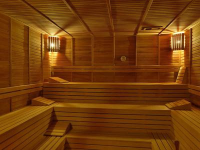 Interior of a wooden sauna with tiered benches and soft lighting on the walls.