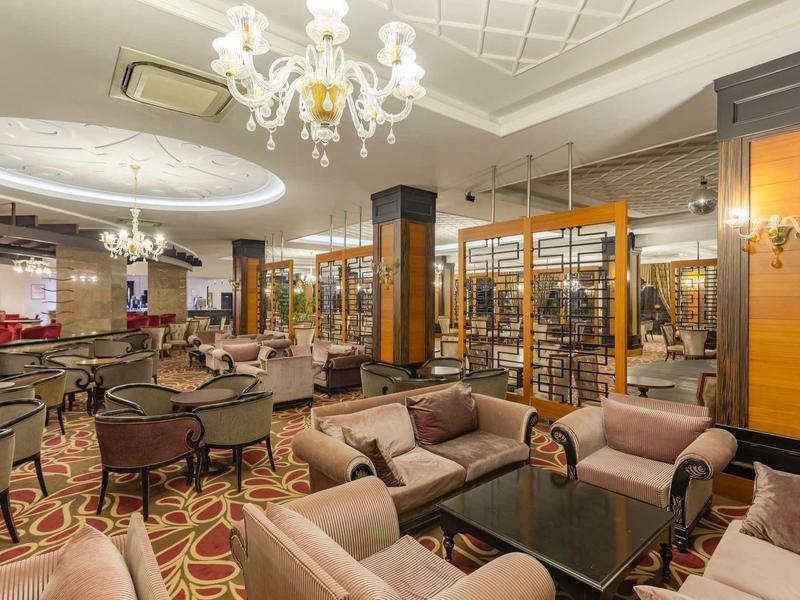 Luxurious hotel lounge with plush sofas, elegant chandeliers, and cozy seating areas.