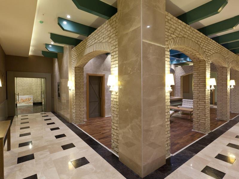 Atrio d'hotel elegante con colonne in marmo e pavimenti piastrellati.