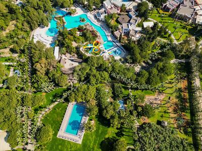 Widok z lotu ptaka hotelu z wieloma basenami otoczonymi zielenią i ogrodami.