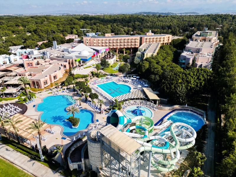 Großes Hotelresort mit mehreren Pools, Wasserrutschen und umgeben von viel Grün.