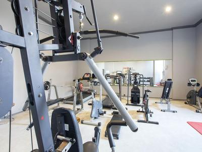 Fitnessraum mit verschiedenen Kraft- und Trainingsgeräten in hellem, modernem Raum.