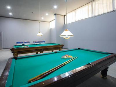 Ein mit Queues und Bällen ausgestatteter Billardtisch in einem hell beleuchteten Raum.