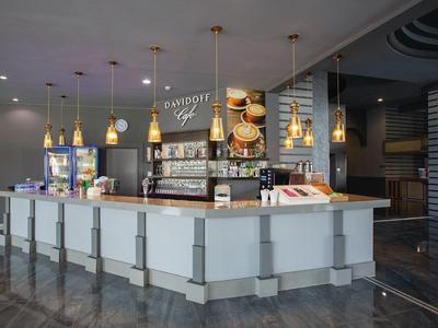 Reception di hotel moderna con bancone elegante e luci calde.