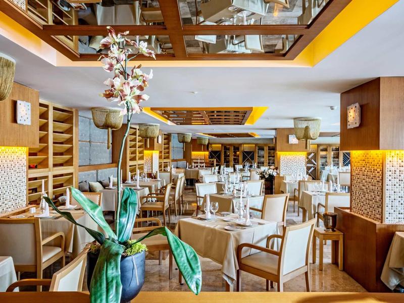 Ristorante d'hotel elegante con mobili in legno, decorazioni da tavola e illuminazione moderna.