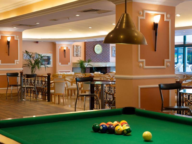 Area giochi accogliente con tavolo da biliardo e posti a sedere in un interno d'hotel caldo ed elegante.