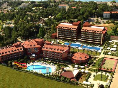 Großes Hotel mit mehreren Gebäuden, zwei Pools, Tennisplätzen und viel Grün rundherum.