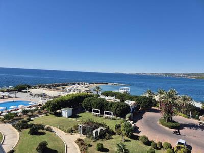 Vue sur la plage, la piscine et le paysage côtier sous un ciel clair