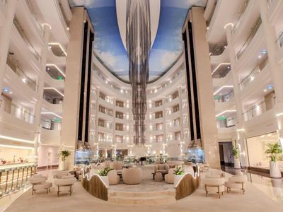 Grand atrium d'hôtel avec sièges modernes, design équilibré et décoration illuminée.