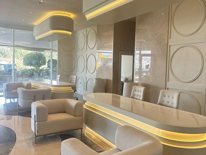 Hall d'hôtel moderne avec éclairage ambiant et mobilier beige élégant.