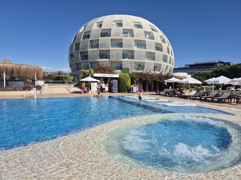 Bâtiment d'hôtel rond avec piscine et jacuzzi sur la terrasse sous un ciel clair