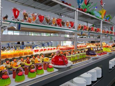 Bunt dekorierte bunte Kuchen und Desserts in einem modernen Buffet mit weißem Geschirr.