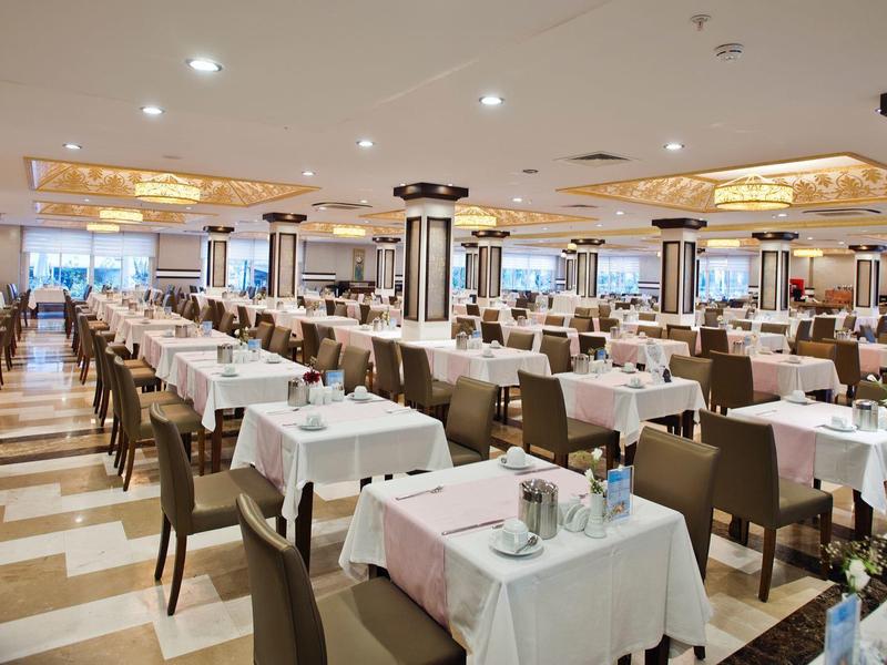 Large elegant dining hall with set tables and chairs in a hotel.