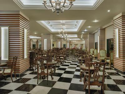 Eleganter Speisesaal mit schwarzem und weißem Schachbrettboden und klassischen Holzmöbeln.