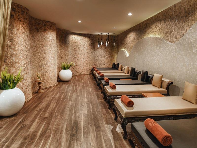 Elegant wellness room with loungers, soft lighting, and stylish wall decorations.