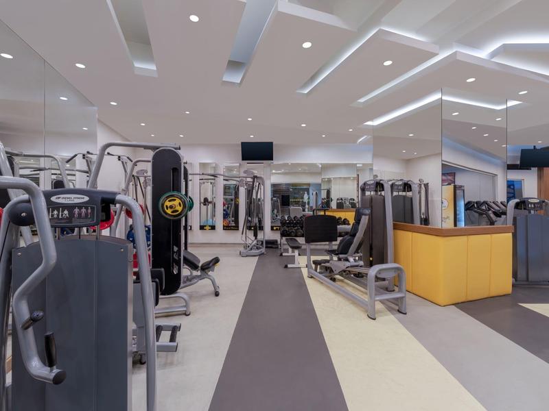 Modern gym with various equipment and bright interior in a hotel.