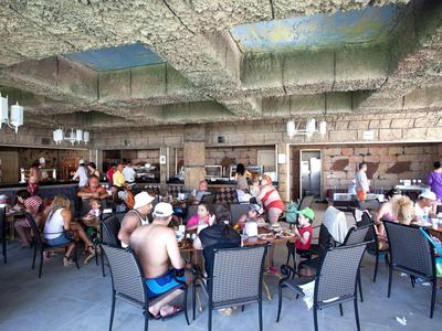 Sala da pranzo vivace con ospiti in abbigliamento casual, atmosfera cordiale.