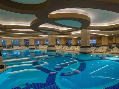 Piscina interna moderna con comode sedute e illuminazione soffusa.