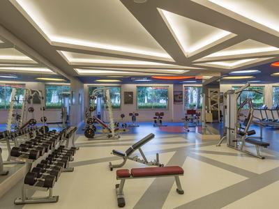Gran gimnasio con equipo de entrenamiento y espacio abierto en un hotel moderno.