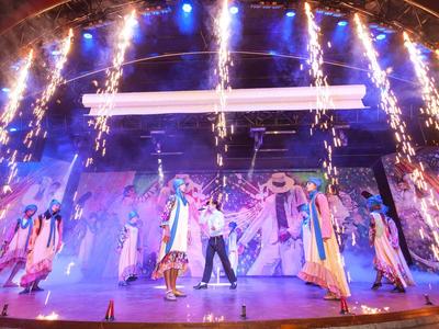 Espectáculo colorido en el escenario con bailarines y efectos de luces brillantes