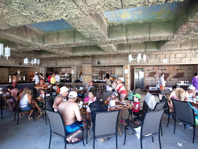 Sala da pranzo vivace con ospiti in abbigliamento casual, atmosfera cordiale.