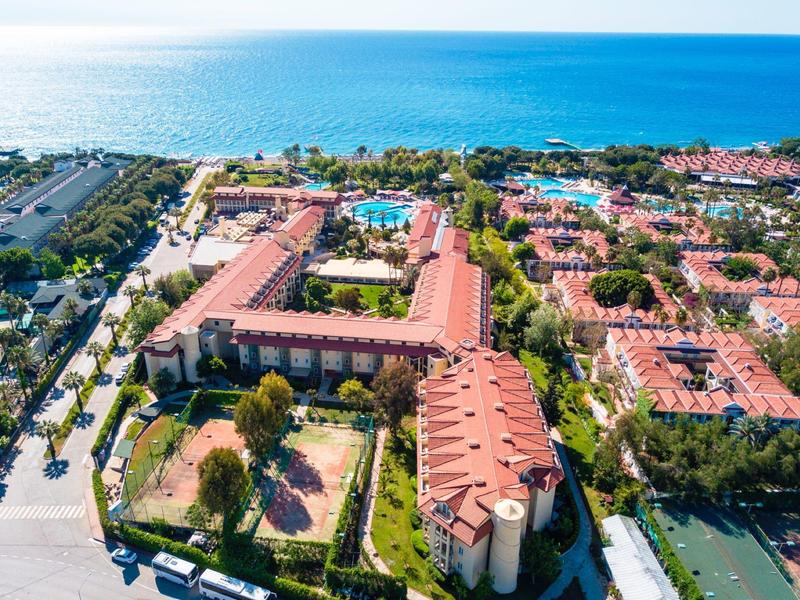 Veduta aerea di un grande resort con più edifici e piscine vicino al mare.