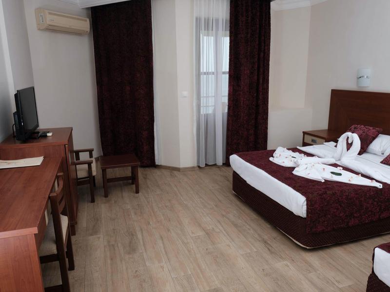 Hotelkamer met twee bedden, bureau, stoelen en raam met gordijnen