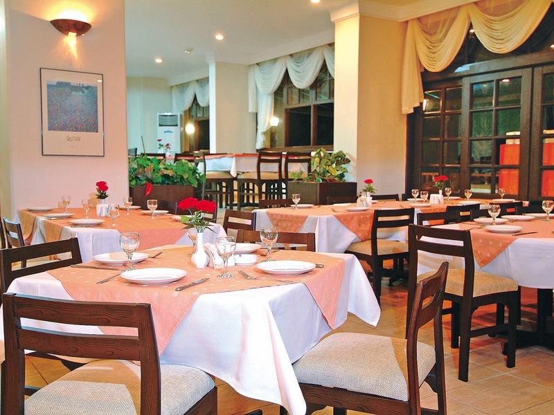 Gezellig hotelrestaurant met gedekte tafels en warme verlichting.