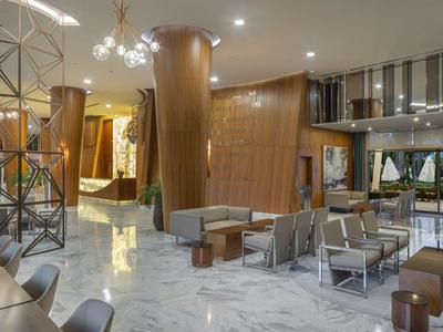 Hall d'hôtel luxueux avec mobilier moderne et décor en bois chaleureux.