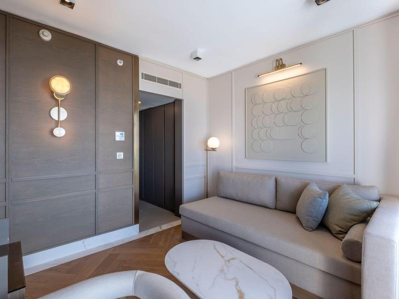 Camera d'albergo moderna con divano, tappeto e decorazione murale.