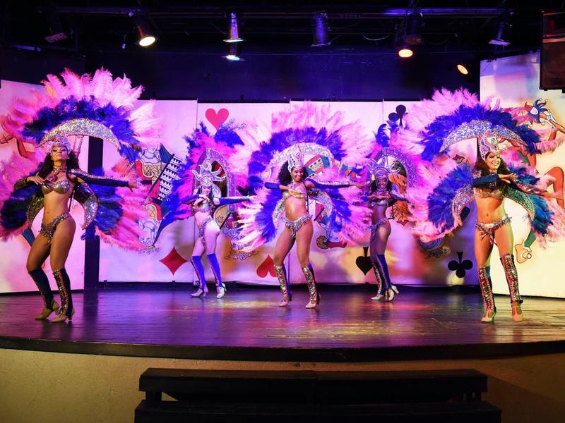 Ballerini con costumi colorati eseguono uno spettacolo vivace su un palco.